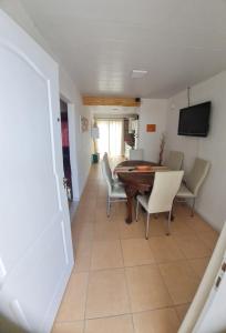 een eetkamer en een woonkamer met een tafel en stoelen bij Vicky House in La Falda