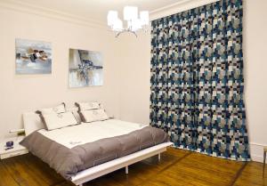a bedroom with a bed and a blue curtain at EXCEPTIONNEL PROPRIETE STANDING 90 m2 PARKING PRIVE BEL EXTERIEUR CENTRE VILLE CLIMATISE in Périgueux