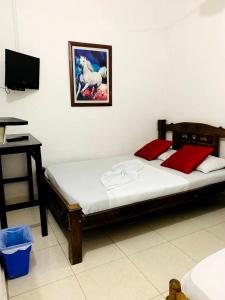 a bedroom with a bed and a desk with avertisement at Hostal La Española de Getsemani in Cartagena de Indias