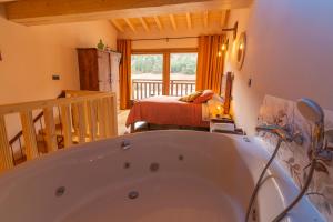 a bathroom with a tub and a bedroom with a bed at La Galiana loft nature in Casarejos