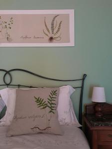 ein Bett mit einem Kissen und einem Bild an der Wand in der Unterkunft Pietra d'Acqua B&B in the woods in Buti