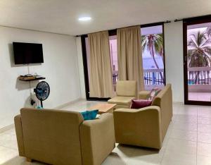 uma sala de estar com 2 cadeiras e uma televisão de ecrã plano em Apartamento Karey 203 Rodadero, Santa Marta em Santa Marta