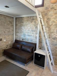 un sofá de cuero sentado en una habitación con una escalera en Villetta Vittoria -Country House-Il fienile en Pennabilli