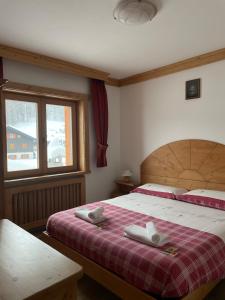 a bedroom with a bed with two towels on it at Chalet Barbara in Livigno