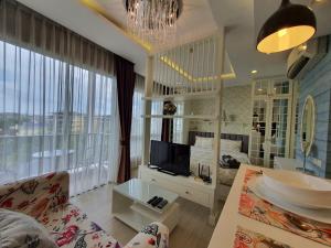 salon z telewizorem i dużym oknem w obiekcie Love & Relax Balcony near WON Beach w mieście Ban Bang Saen (1)