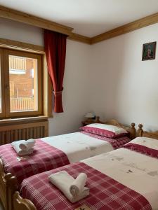a bedroom with two beds and a window at Chalet Barbara in Livigno