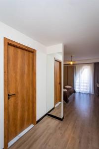 an empty room with a wooden door and a bedroom at Ski Escape Apartment in Gudauri in Gudauri