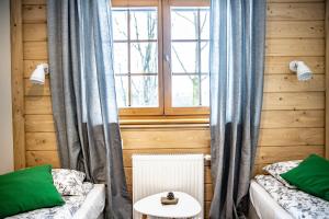 a room with two beds and a table and a window at Willa Leluja in Zakopane