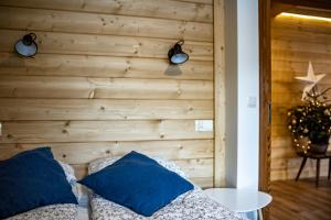 a bedroom with a wooden wall with blue pillows at Willa Leluja in Zakopane
