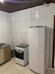 a kitchen with a stove and a refrigerator at Chalés Vô João in Penha +5 photos