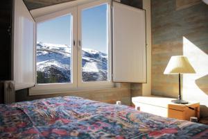 1 dormitorio con cama y vistas a una montaña nevada en Miramar Ski a pie de pista, en Sierra Nevada 65 fotos más