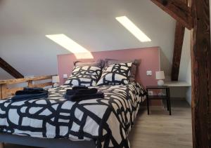 1 dormitorio con 1 cama con edredón blanco y negro en Cosis Colmar - 2 Chambres - 4 Pers - Duplex - Parking - Wifi, en Colmar
