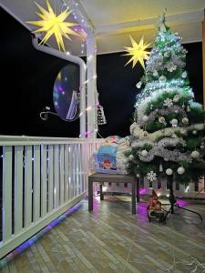 a christmas tree in a room with a crib and a tv at OAZA in Mokra Gora