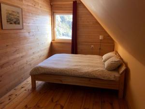 sypialnia z łóżkiem w pokoju z oknem w obiekcie Forest house Einblūti w mieście Avotkalni