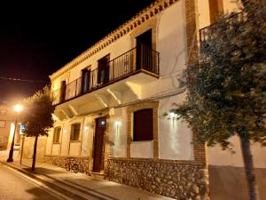 um edifício com uma varanda numa rua à noite em Alojamiento con amplio salón y chimenea. em Valverde
