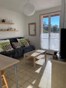 uma sala de estar com um sofá e uma mesa em T2 Classé 2* calme au coeur du village provençale em Gréoux-les-Bains