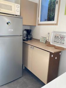 uma pequena cozinha com frigorífico e micro-ondas em T2 Classé 2* calme au coeur du village provençale em Gréoux-les-Bains