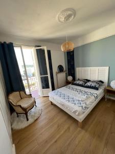 een slaapkamer met een bed en een stoel erin bij Appartement climatisé F3 proche plage port et aéroport in Ajaccio