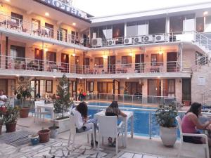 a group of people sitting around a pool in a hotel at Alida Hotel in Pamukkale