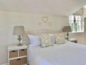 Anchor's Rest في هيرمانوس: غرفة نوم مع سرير أبيض مع قلوب على الحائط