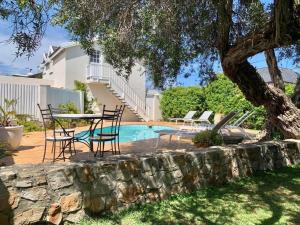 a patio with a table and chairs next to a pool at Anchor's Rest in Hermanus