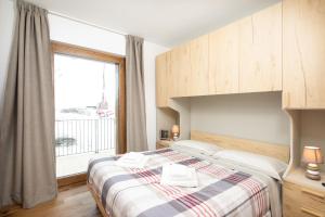 a bedroom with a bed with a large window at Casa Noemi in Livigno