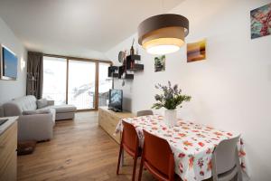 uma sala de estar com uma mesa com um vaso de flores em Casa Noemi em Livigno
