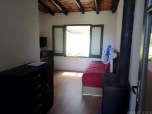 een slaapkamer met een bed en een raam met een ventilator bij Tembetarí in Cuchilla Alta