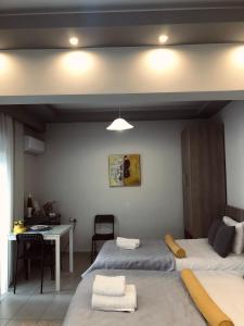 een slaapkamer met 2 bedden, een bureau en een tafel bij Xenia_Apartments A7 in Kozani