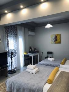 Xenia_Apartments A7 في كوزاني: غرفة نوم بسريرين ومكتب فيها