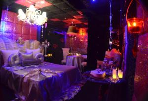 um quarto com iluminação roxa e uma cama e mesas em Xcite Hotel Salem em Atenas