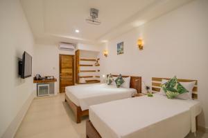 a bedroom with two beds and a tv in it at Palma Resort in Phú Quốc