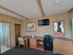 a room with a desk and a tv on the wall at Townhouse Motel in Bishop
