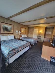 a hotel room with two beds and a desk at Townhouse Motel in Bishop