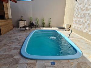 a swimming pool with a blue tub in a patio at Recanto H & E in Olímpia