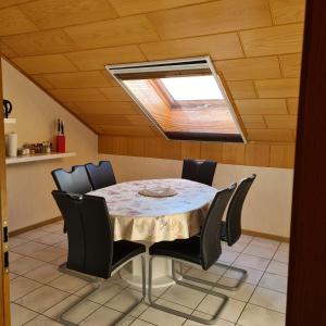 a dining room with a table with chairs and a skylight at Ferienwohnung Cornelia und Michael Persang GbR in Eppenbrunn