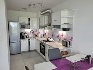 uma cozinha com electrodomésticos brancos e uma bancada roxa em Bayview B32 - Burgas Beach Resort em Burgas