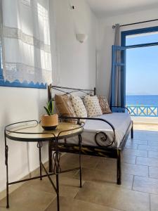 a bedroom with a bed with a table and a window at Alisachni Villas in Lefkos Karpathou