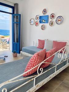 a bedroom with a bed with red pillows and plates on the wall at Alisachni Villas in Lefkos Karpathou +30 photos