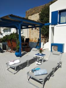 eine Gruppe von Stühlen und Tischen auf einer Terrasse in der Unterkunft IVISKOS House, Megalo Horio village, Tilos Island in Megálon Choríon