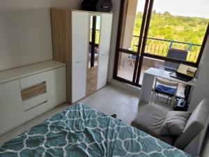 um quarto com uma cama, uma secretária e uma janela em Bayview B32 - Burgas Beach Resort em Burgas