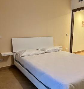 uma cama branca com duas almofadas num quarto em ComeCasa modern apartment in historical centre em Asti