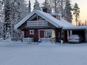 a house with a car parked in the snow at Villa Bear's in Rovaniemi