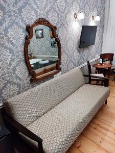 un sofá en una habitación con un espejo en la pared en Always Welcome, en Tiflis
