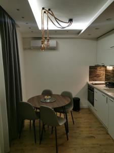 a dining room with a table and chairs in a kitchen at Apartman Hill in Mirijevo