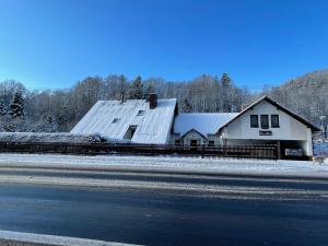 a house on the side of a road with snow at Pension Polonia in Vrchlabí