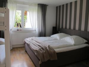 a bedroom with a bed with white sheets and a window at Ferienwohnung Pracht - großzügige FeWo ab 75 qm in Rust