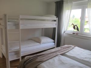 a bedroom with two bunk beds next to a window at Ferienwohnung Pracht - großzügige FeWo ab 75 qm in Rust