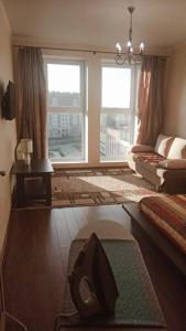 ein Wohnzimmer mit einem großen Fenster und einem Sofa in der Unterkunft Apartent Turgeneva 10G in Selenogradsk