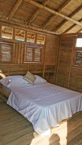 un grande letto bianco in una camera con soffitti in legno di Pachingo Tatacoa Desert a La Victoria